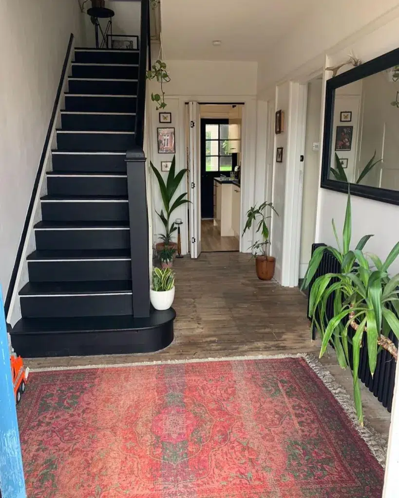 31 Black And White Stairs That Are Sure To Stun 4 Black Stairs With White-Nose Edging And White Side Trim In A Home With Rustic Wood Floors