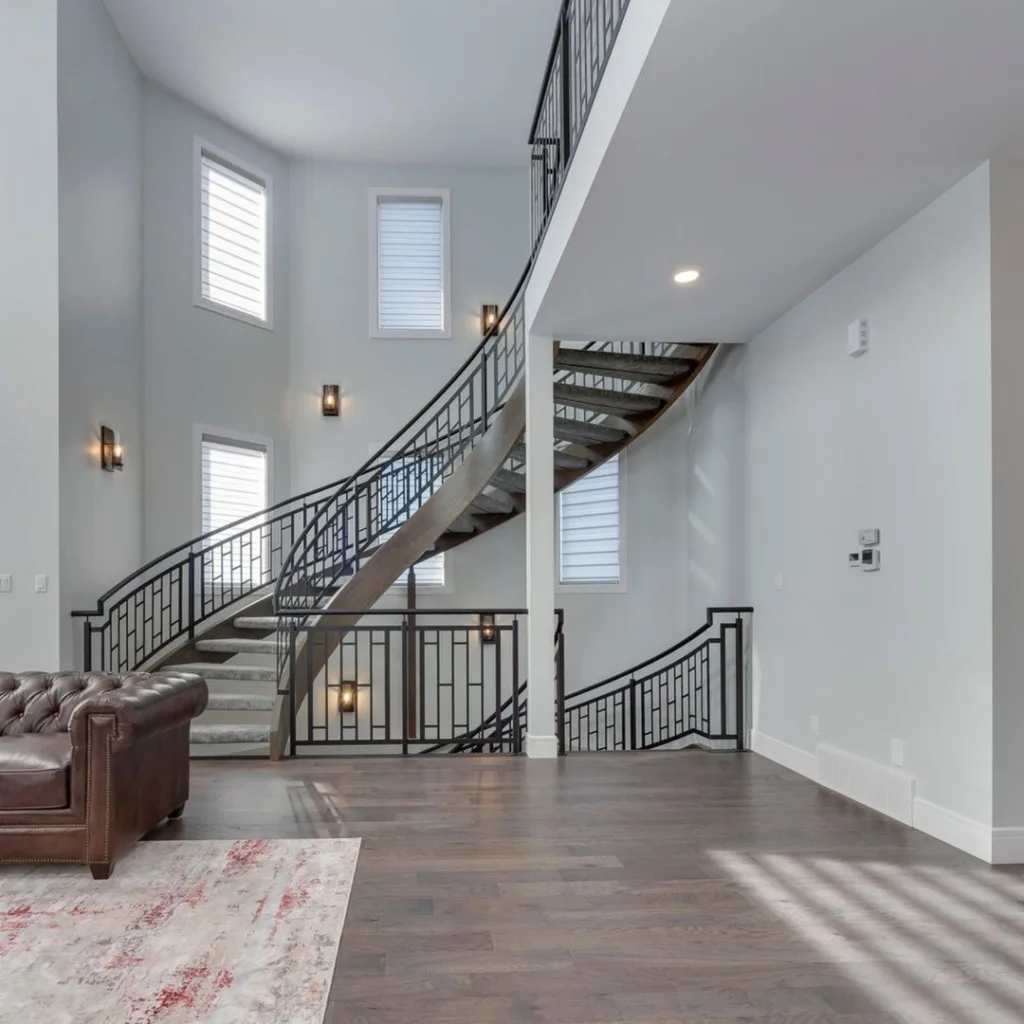24 Curved Staircases For Design And Decor Inspiration 4 A Double Height Living Room With A Curved Metal Staircase Leading Upwards And Downwards