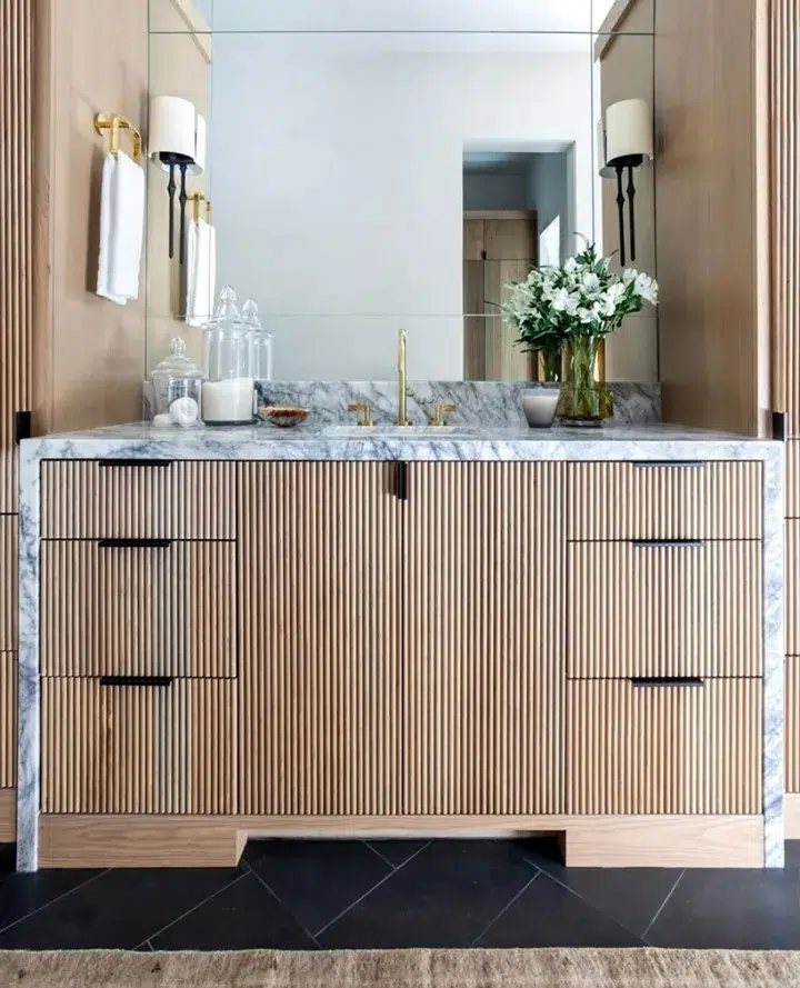 35 Bathroom Counter Decor Ideas 23 A Wood Trim Vanity With A Marble Waterfall Edge