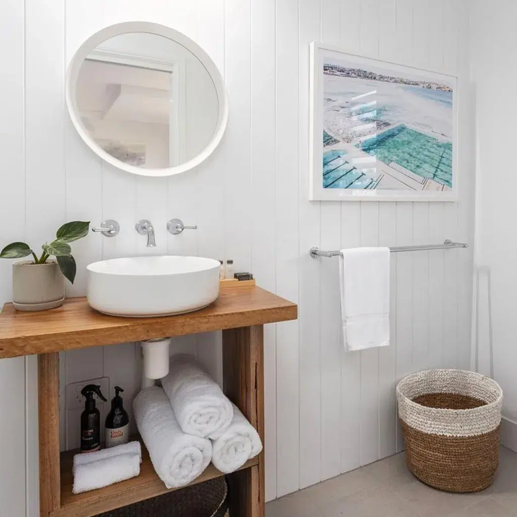 35 Bathroom Counter Decor Ideas 22 A White Vertical Shiplap Bathroom With A Beige Planter On The Wood Vanity For Decor