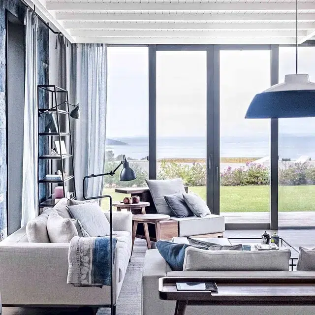 31 Coastal Beach-Themed Living Room Ideas 13 A Coastal Theme Living Room With A Modern Grey Couch And Furniture