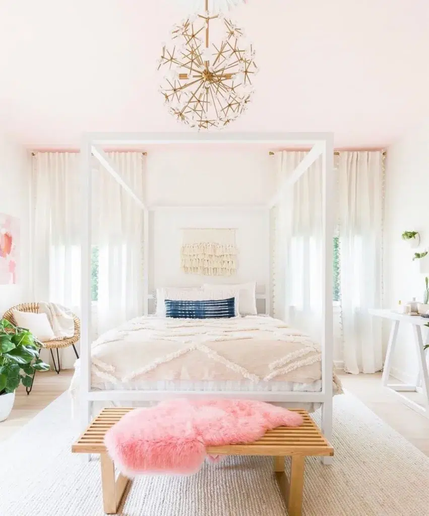 A Girls Room With Pink Bedding And A Large Neutral Rug With A Bench On It