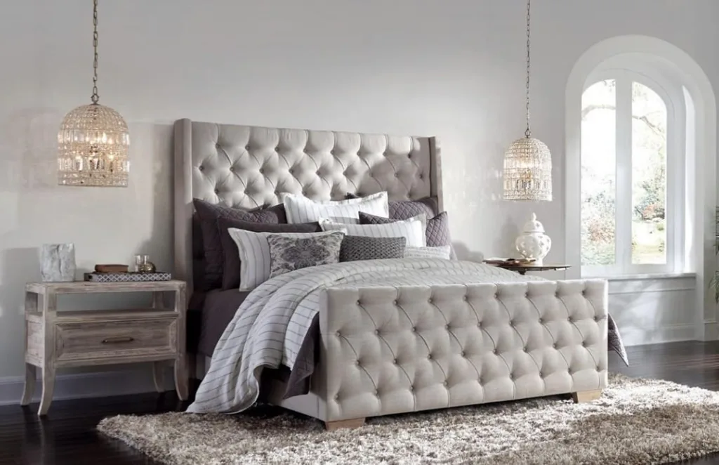 A Grey Tufted Bed On A Grey Plush Carpet With Pendant Lights Over The Nightstands