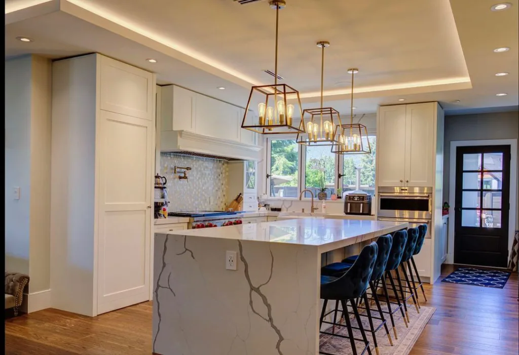 32 Waterfall Kitchen Island Ideas For Inspiration 1 A White And Grey Quartz Waterfall Island With Blue Chairs