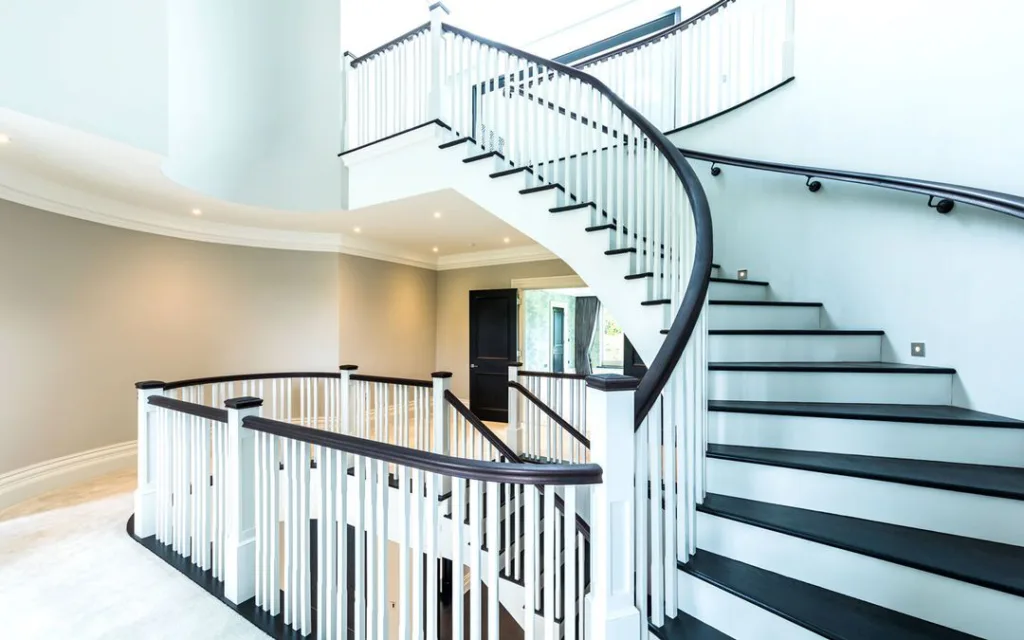 White And Black Wood Curved Stairs In A Home With Carpets