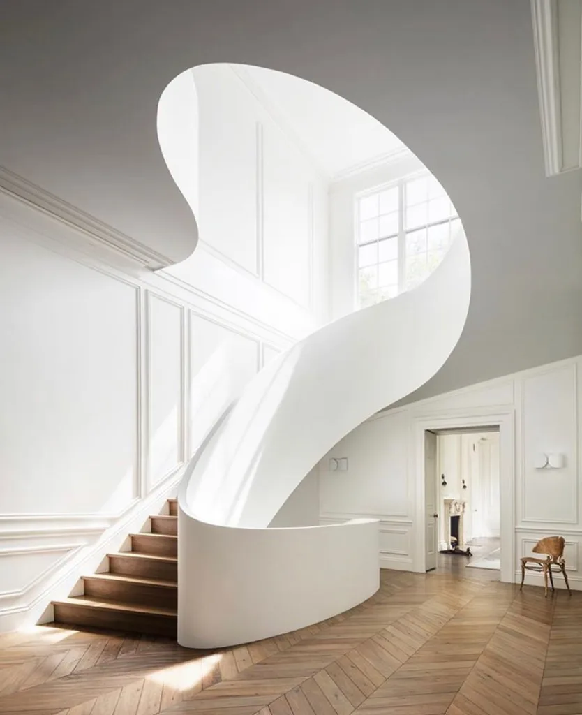 Curved Stairs With Leading Upwards To The Next Floor In A White Wall Entryway With Molding