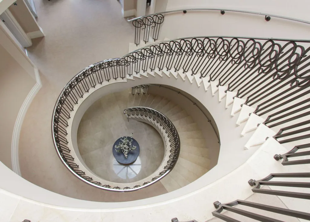 24 Curved Staircases For Design And Decor Inspiration 20 Curved Staircase With Wooden Steps And A Wrought-Iron Railing