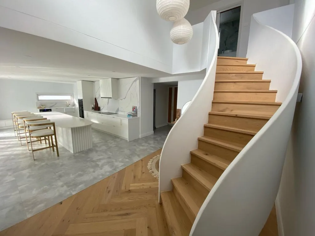 Curved Stairs With Neutral Color Planks And White Solid Railings