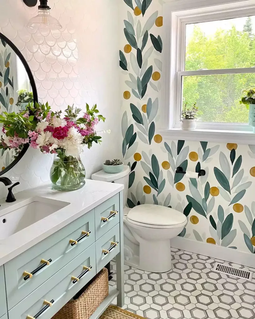 38 Bathrooms With Hexagon Tile Floors 1 Hexagon Bathroom Floor Tiles In A Light Grey Shade Complemented By A Vibrant Floral Wallpaper On The Walls. White Subway Tiles Are Used For The Shower Area And Sink Backsplash, While The Cupboards Are Painted In A Cheerful Sky Blue Hue. A Small Flower Pot Sits On The Countertop, Adding A Touch Of Natural Beauty To The Space.