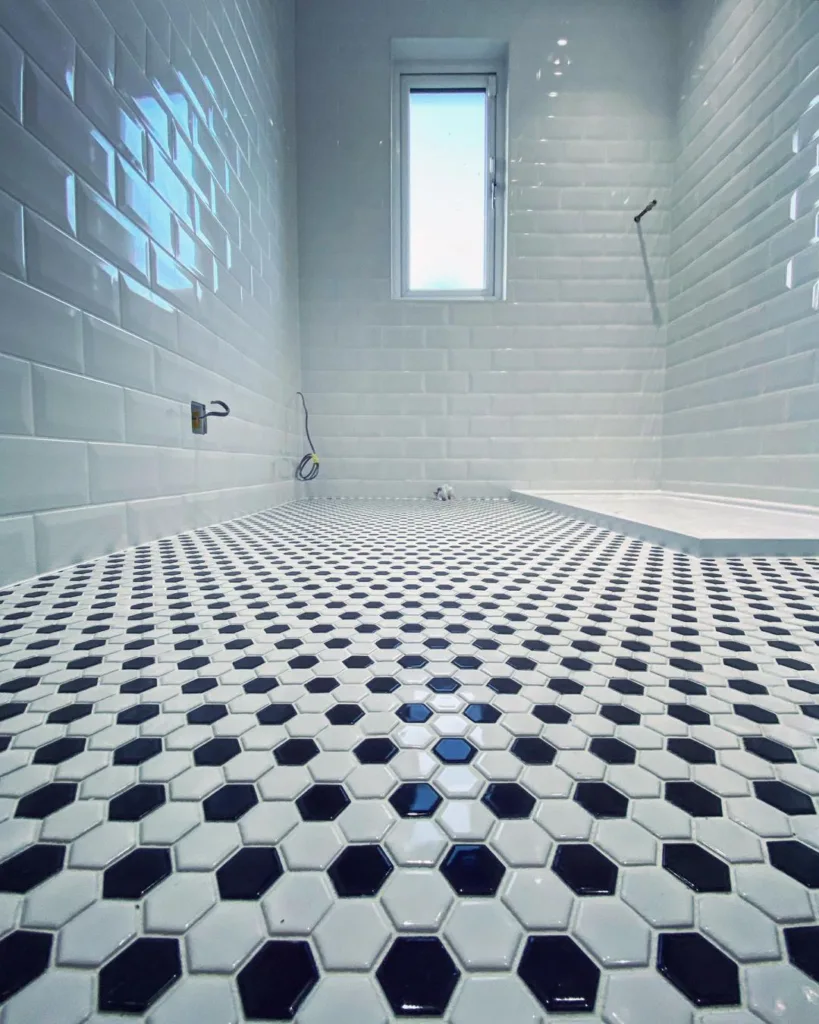 38 Bathrooms With Hexagon Tile Floors 3 A Stylish Black And White Bathroom With Hexagonal Floor Tiles In A Classic Pattern. The Walls Are Covered In White Tiles With A Glossy Finish, Creating A Bright And Airy Atmosphere.
